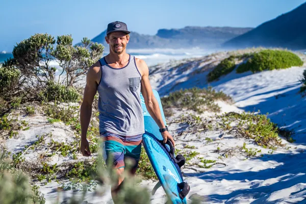 Windsurfer Florian Jung on the beach with his surfboard