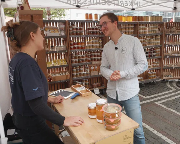 Julius talking to customers at the Honighalle market stand
