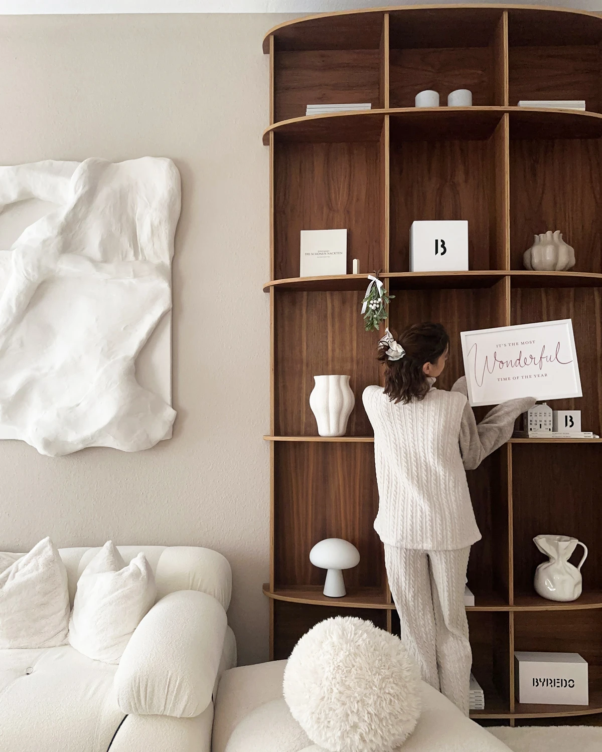 Maddy is decorating her large, semicircular walnut bookshelf