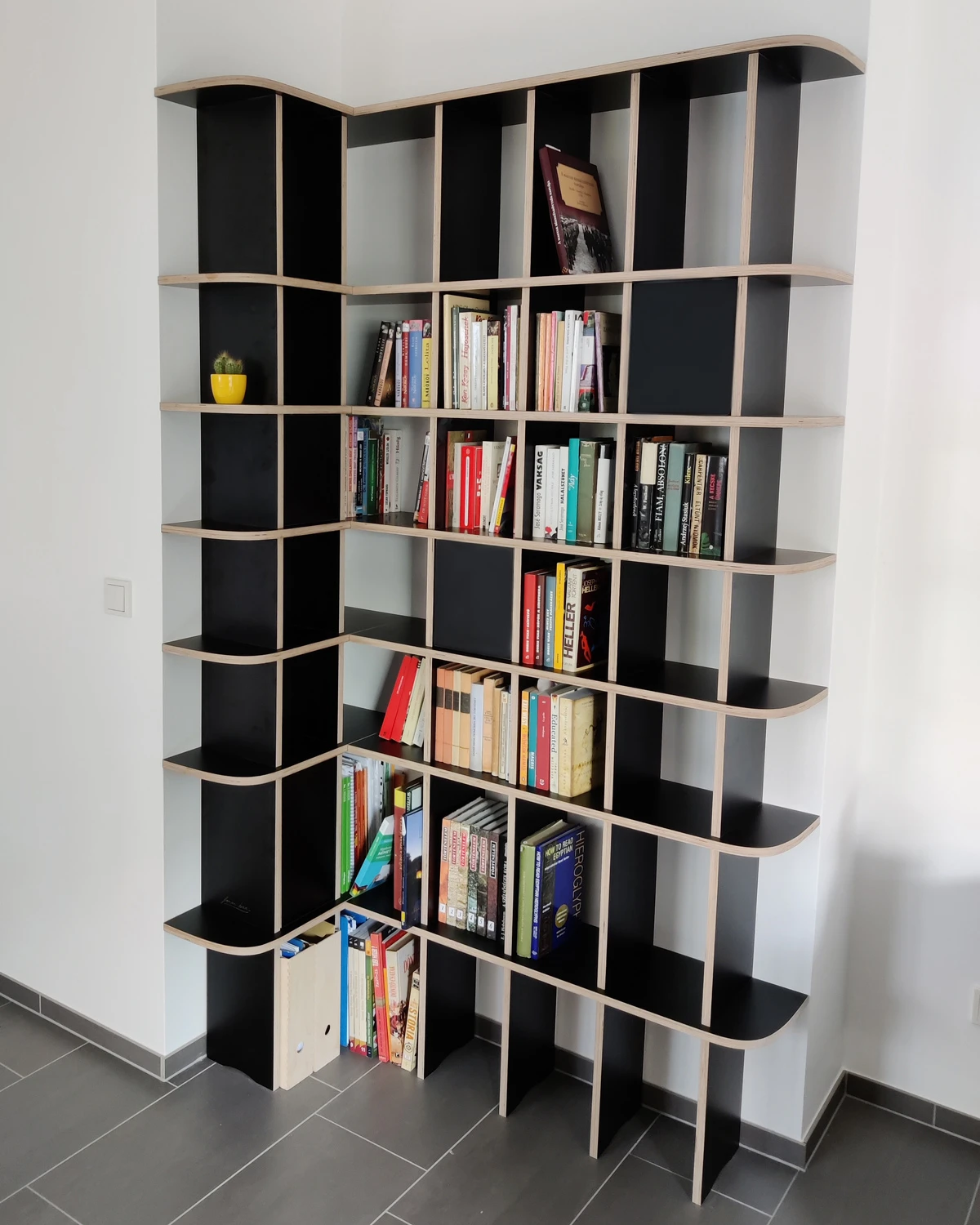 Schwarzes Eckregal in komplizierter Ecke