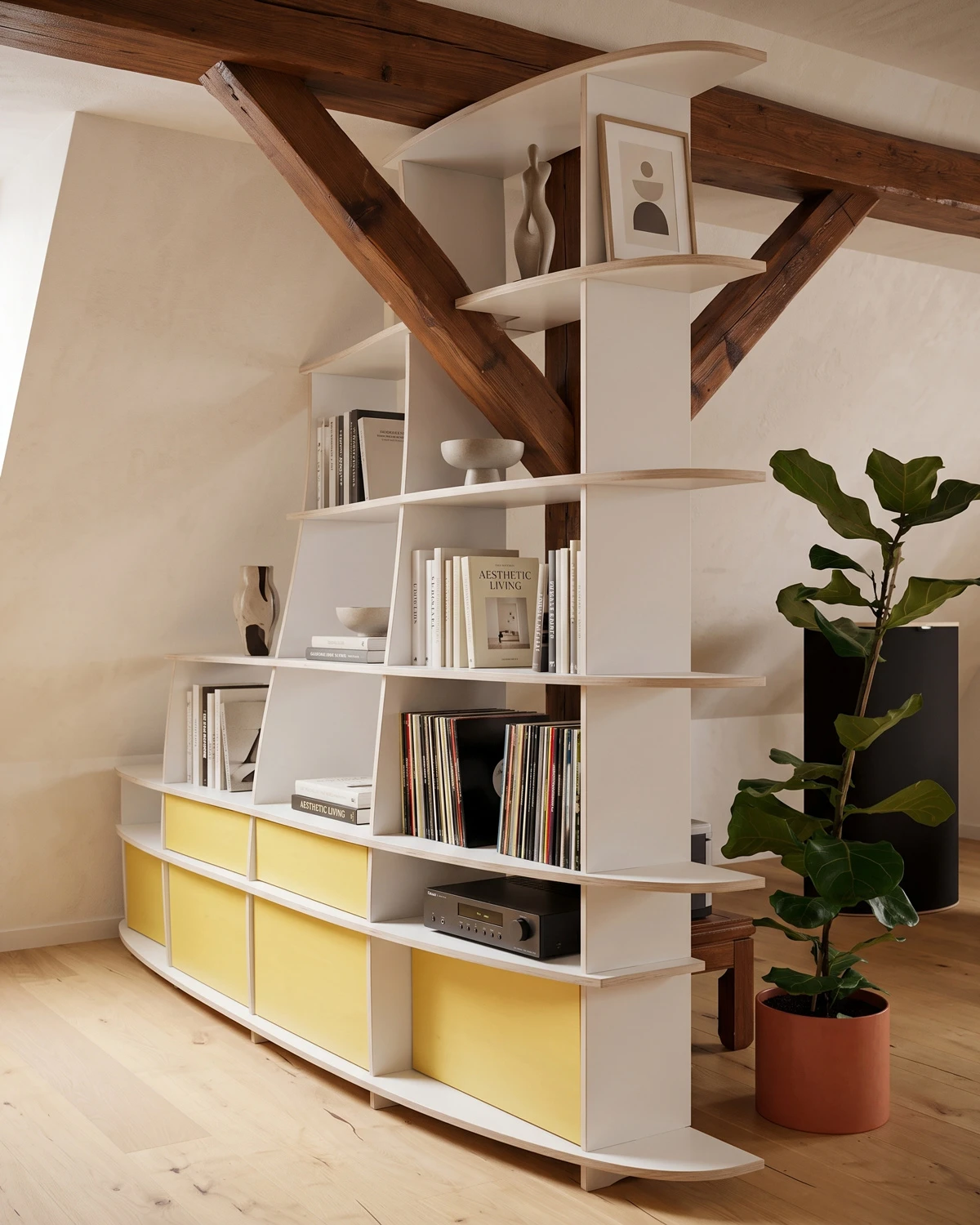 Cloison blanche aux lignes organiques, dotée d'une poutre de soutien intégrée, installée sous un plafond en pente, avec des portes jaunes et des compartiments ouverts