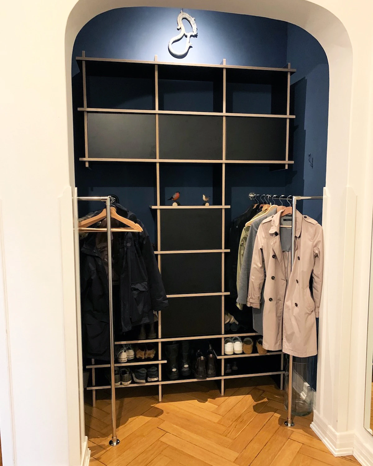 Vestiaire noir dans une niche avec penderies, compartiments ouverts, rangement chaussures et manteaux dans une entrée